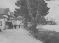 During the visit of the Duke of Gloucester to New Zealand a stop-over was made in the Bay of Islands. Seen here are some of the ship's company walking along the waterfront of the historic town of Russell. 26.1.35,