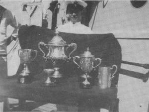"AUSTRALIA" won the "Med Fleet" Regatta two years running. Here a proud petty officer displays some of the trophies that the grand old lady won.
