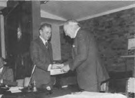The President, Mr Lew Lind, makes a presentation to Admiral Sir Victor Smith at the 1975 Society Dinner.