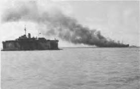 HMAS KATOOMBA high and dry in the floating dock with ship on fire in the baclaground