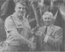 Sergeant Mark Holloway presents a pair of binoculars belonging to the late Commander J.F. Rayment to his son, Mike.