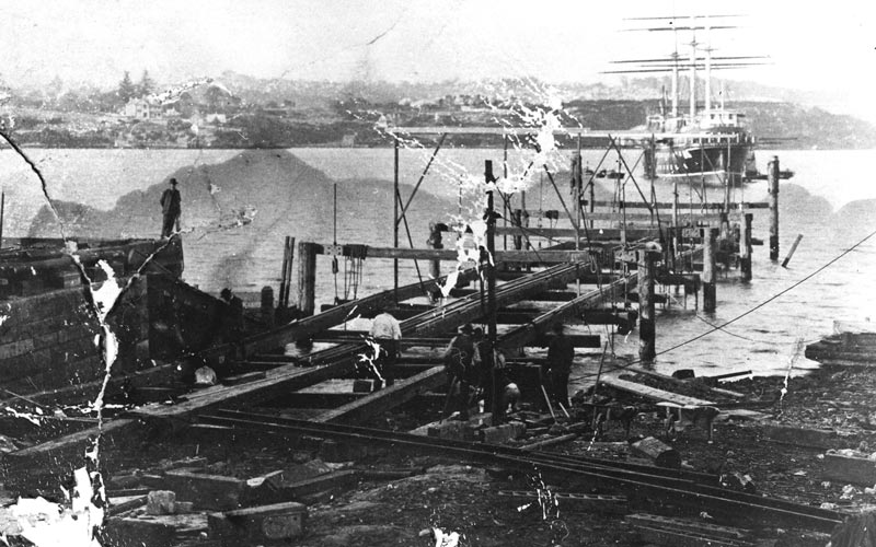 The 500 ton slipway under construction in 1909 with the school ship Sobraon in the background